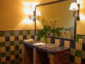 Aseos de la planta baja, con azulejos azules, verdes y blancos, y lebrillos de fajalauza granadina que dan a los baños un aire castizo y encantador.