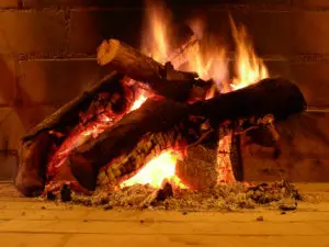 Detalle de la leña ardiendo en la chimenea del salón del hotel Huerta Nazarí