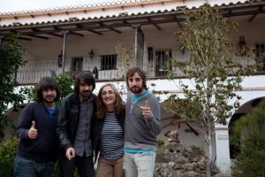 Alfredo, Noni y Alejandro posan junto a Ángela Jiménez Egea, directora del hotel Huerta Nazarí. Tras ellos se ve la galería porticada del patio y las terrazas de las habitaciones del hotel que dan al jardín.