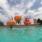 Niños lanzándose al agua en la piscina